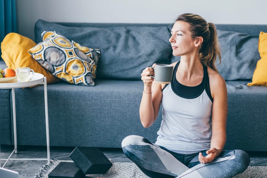 Woman enjoying a cup of kava after a workout to relax the muscles